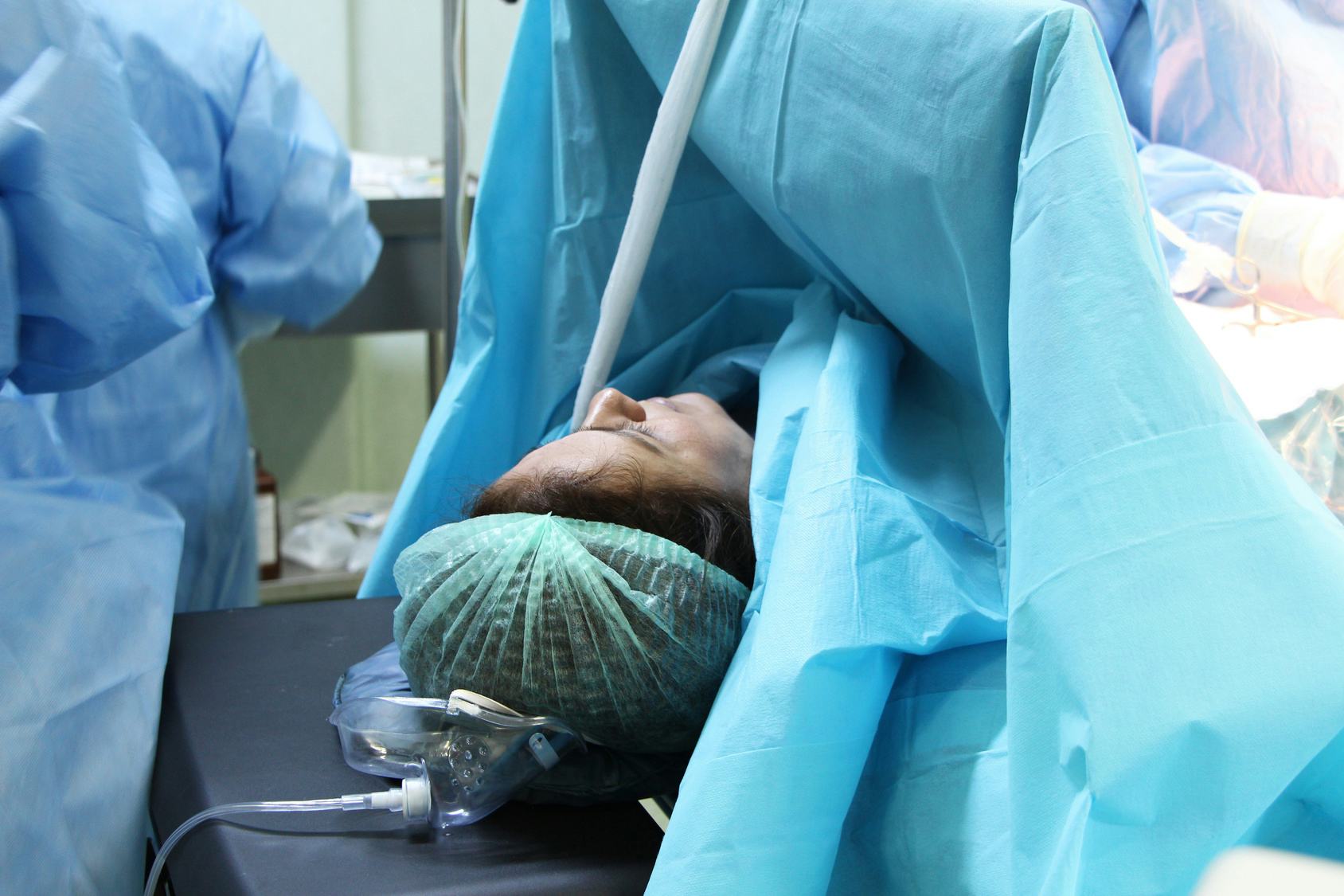 Woman having c-section delivering baby