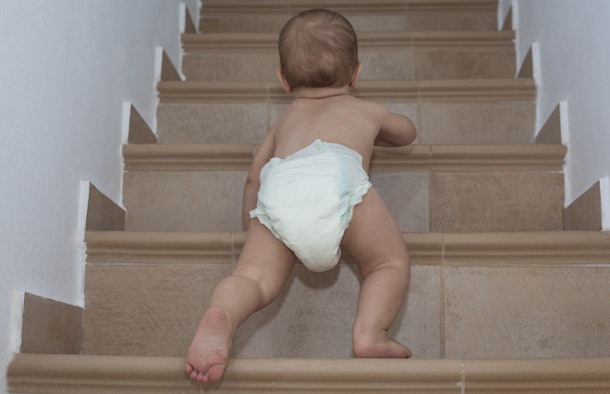 Boy crawls on the stairs. Low viewing angle
